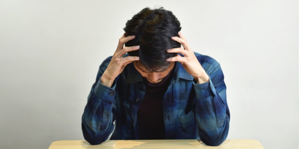 頭を抱えた男性